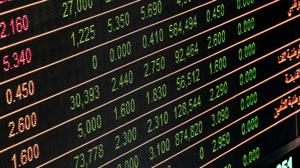 Electronic stock quote board with orange, green and red prices