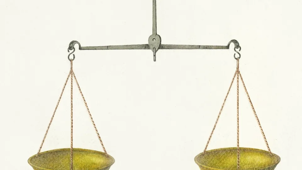 Antique balance scale with two brass pans hanging level from a central beam